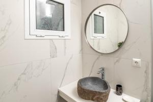 a bathroom with a stone sink and a mirror at Sea Bliss Adults Only in Parga