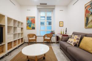 salon z kanapą i stołem w obiekcie Apartamento cerca de la catedral w Sewilli