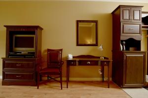 ein Wohnzimmer mit einem TV, einem Stuhl und einem Schreibtisch in der Unterkunft Motel du Littoral in Rimouski