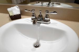 un lavandino in bagno con rubinetto cromato e specchio di Motel du Littoral a Rimouski