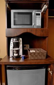 a microwave on a shelf next to a refrigerator at Motel du Littoral in Rimouski