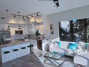 a living room with a white couch and a kitchen at Lux place and cozy 3Beds 2Rooms enjoy life in WPB Gym, EV Station Nearby the downtown and beaches in West Palm Beach