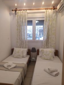 two beds in a room with a window at Apartment Ioanna #2 in Kallithea Halkidikis