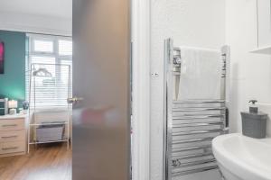 a white bathroom with a sink and a towel rack at Milton House Private Room 6 in Cambridge - Perfect for Contractors and Solo Traveler in Cambridge