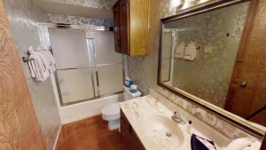 a bathroom with a sink and a toilet and a mirror at Grandview 10 Townhouse With High Speed Wifi in Red River +15 photos