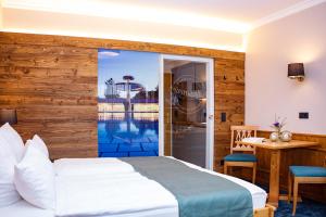 バート・フュッシンクにあるAppartementhaus Absmeierのベッド付きのホテルルームで、プールの景色を望めます。