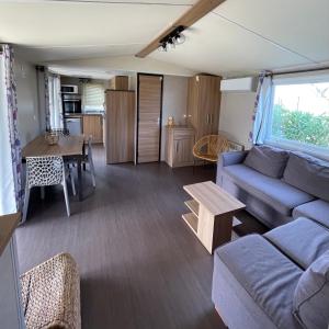 salon z kanapą i stołem w obiekcie Parc Résidentiel La Listra - Bungalow w mieście Belgodère