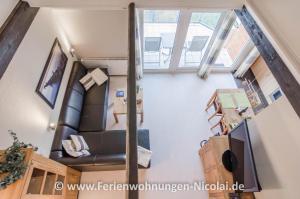uma vista sobre uma sala de estar com um sofá de couro preto em Panorama Schönberger-Strand Appartement 29 em Stakendorfer Strand
