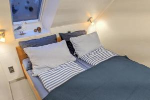 uma cama com duas almofadas em cima em Panorama Schönberger-Strand Appartement 29 em Stakendorfer Strand