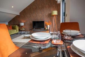 una sala da pranzo con un tavolo con piatti e bicchieri da vino di The Quadrant - The Garret a York Altre 38 foto
