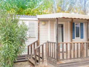 a small house with a porch and a deck at Camping Pleine Mer in Vias