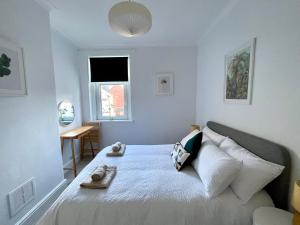 a white bedroom with a bed with towels on it at TAFFS MEAD HOUSE Central City Location, nr Stadium, Family Friendly in Cardiff