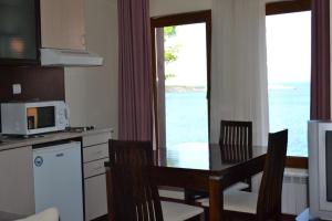 a kitchen with a table and chairs with a view of the ocean at Hotel Diamanti in Sozopol