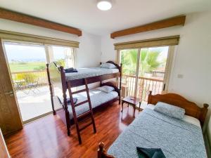 a bedroom with two bunk beds and a balcony at Sunnyside Pool Villa in Ayia Napa