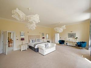 um quarto grande com uma cama, uma mesa e cadeiras em 6 Bedroom Luxury Manor House em Newbury