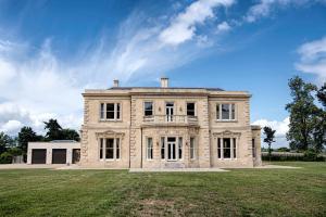 uma grande casa de pedra no topo de um campo em 6 Bedroom Luxury Manor House em Newbury