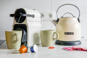 une cafetière et deux tasses sur un comptoir dans l'établissement Homefy Come-Together Apartment - Balkon - Aufzug - Free Parking - Smart TVs, à Essen