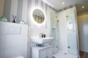 um banheiro branco com pia e chuveiro em HOMEFY - Come Together Apartment em Essen mais 10 fotografias