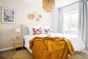 - une chambre avec un lit doté d'une couverture jaune dans l'établissement Homefy Come-Together Apartment - Balkon - Aufzug - Free Parking - Smart TVs, à Essen