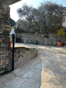 a stone wall with a gate and a patio at Greenlake House Tremezzina in Tremezzo