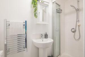 y baño blanco con lavabo y ducha. en Milton House Private Room 7 in Cambridge - Perfect for Contractors and Solo Traveler, en Cambridge