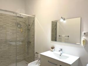 a bathroom with a shower and a sink and a mirror at Beach Front House in Ponta Delgada +27 photos