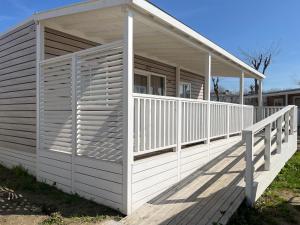 a white house with a porch and a balcony at Club del Sole Rimini Family Resort in Rimini