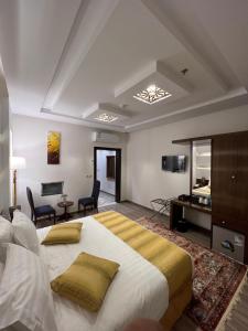 a bedroom with a large bed and a living room at فندق الليالي الحالمة in Medina