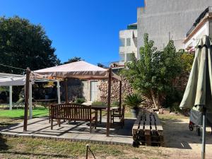 un patio con mesa, bancos y sombrilla en La Casita de Las Estrellas, en Algimia de Almonacid