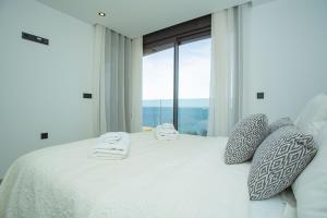 a bedroom with a white bed with a large window at 138 Miramar Luxury Relax - Alicante Holiday in La Mata