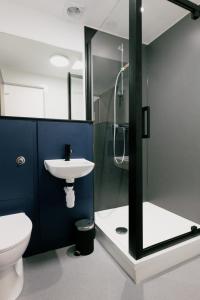 a bathroom with a shower and a toilet and a sink at The Base Camp Hotel, Nevis Range in Fort William