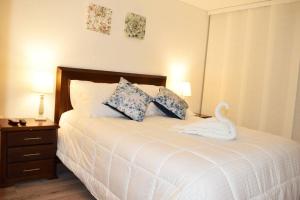 a bedroom with a bed with a swan on it at Amplio apartamento lujoso al lado del lago in Paipa +38 photos