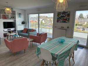 sala de estar con mesa y sillas en Les Terrasses Marines - Vue imprenable sur le port de plaisance, en Vannes