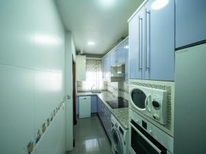 una cocina blanca con lavadora y secadora. en Center Luxury fjhomefj, en Jerez de la Frontera