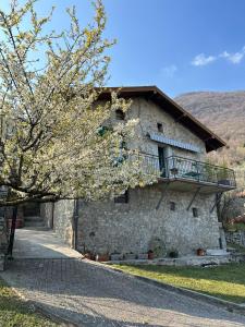 um edifício de pedra com uma varanda em cima em Greenlake House Tremezzina em Tremezzo