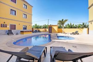 a patio with chairs and a swimming pool at Apartamento Tazacorte in Tazacorte