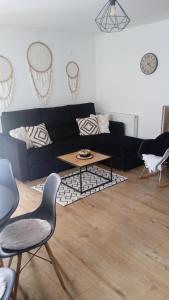 a living room with a black couch and a table at Apartament w Pieninach in Krościenko