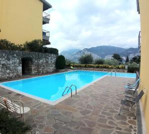 una piscina en una villa con montañas en el fondo en Residence La Perla Malcesine, en Malcesine