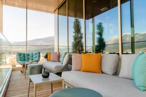 a living room with a couch and some windows at Motel One Innsbruck in Innsbruck