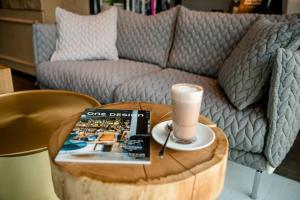 a coffee table with a book and a cup on top of a barrel at Motel One Innsbruck in Innsbruck