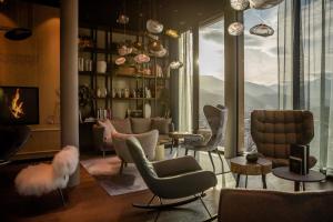 a living room filled with furniture and a large window at Motel One Innsbruck in Innsbruck