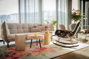 a living room with a couch and a table and chairs at Motel One Innsbruck in Innsbruck