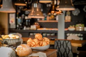 a table with a bowl of croissants and other bread at Motel One Innsbruck in Innsbruck