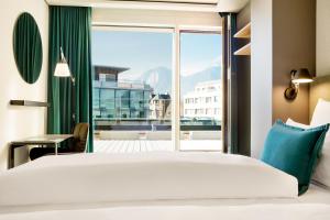 a bedroom with a bed and a large window at Motel One Innsbruck in Innsbruck