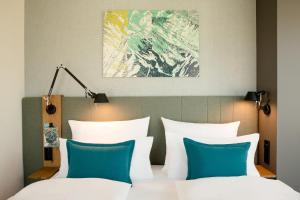 a bedroom with a bed with white and blue pillows at Motel One Innsbruck in Innsbruck