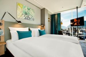 a hotel room with two beds and a large window at Motel One Innsbruck in Innsbruck