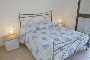 a bedroom with a bed and two lamps on tables at Acquadolce in San Teodoro