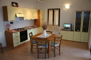 a kitchen with a table and chairs and a television at Acquadolce in San Teodoro