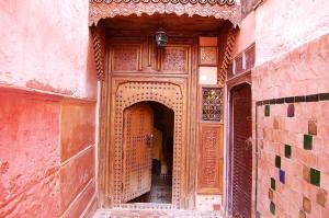 uma entrada para um edifício com uma porta de madeira em Riad Benchekroun em Meknès