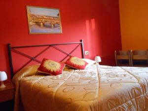 una camera rossa con un letto con due cuscini rossi di Hotel Aline a Firenze